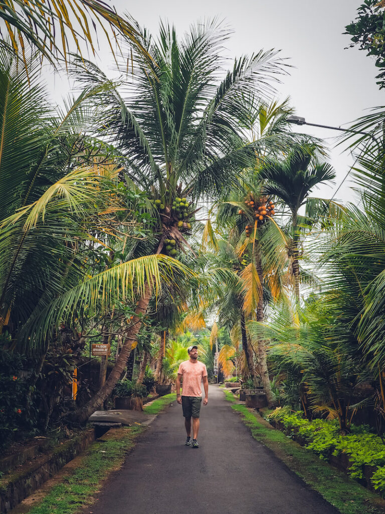 homme qui marche dans une ruelle d'un village typique de Bali