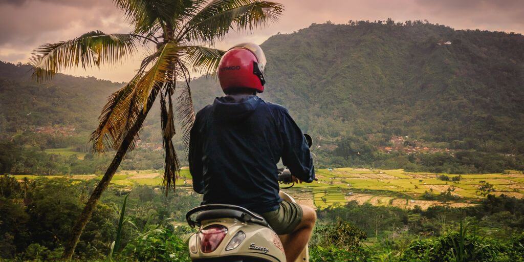 personne sur un scooter admirant un point de vue sur des rizières à Bali