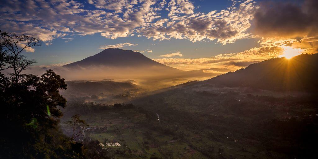 lever de soleil depuis un point de vue sur la vallée de Sidemen avec rizières et volcan Agung